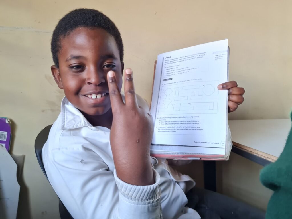 Child at PYMA holding a book while smiling